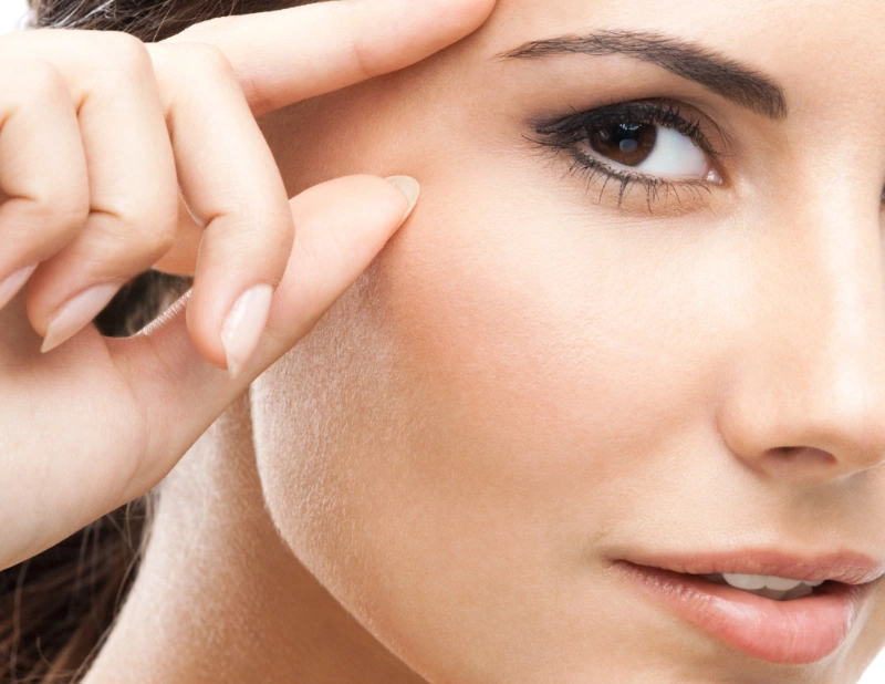 Up close image of woman touching her face